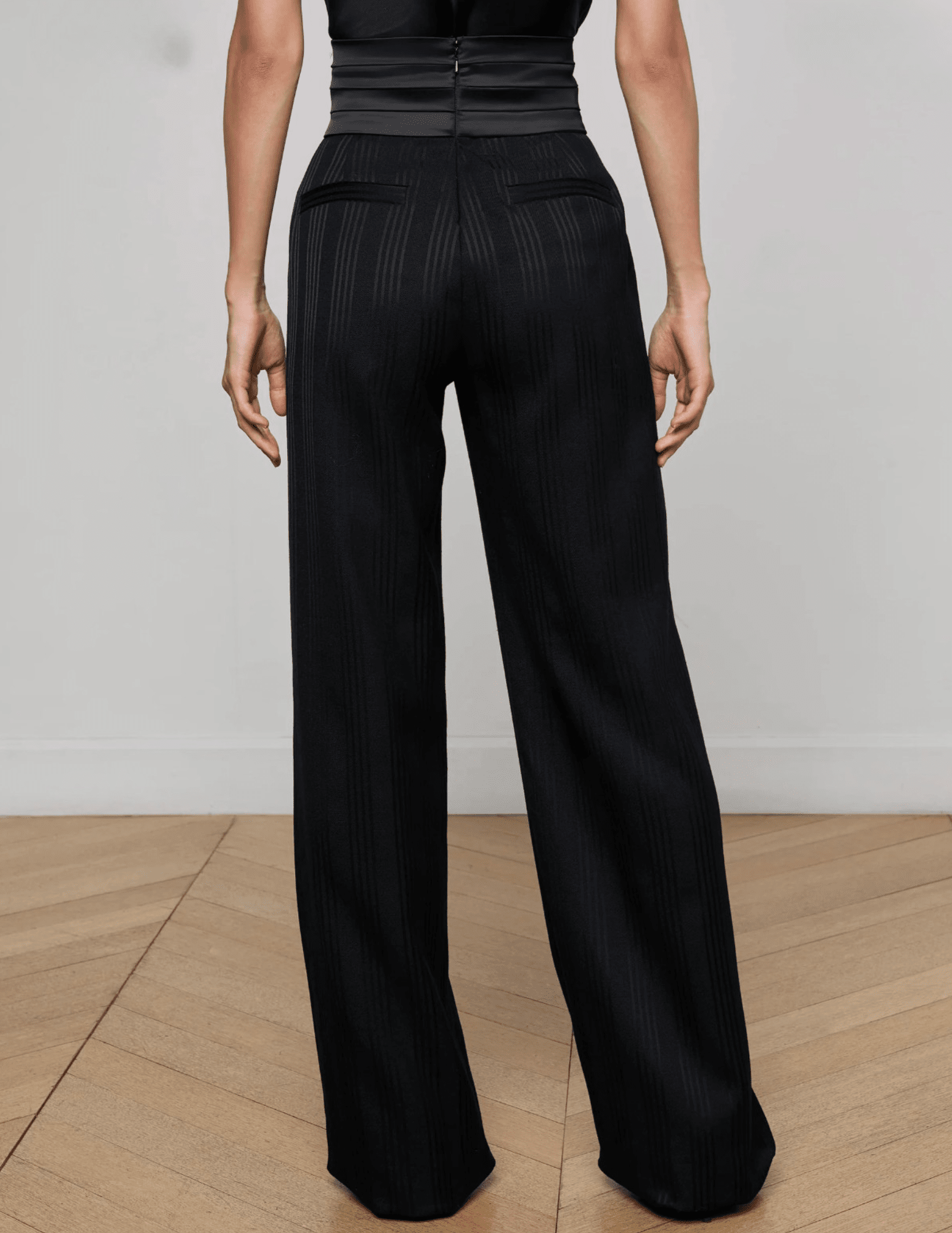 Back view of L’AGENCE Minerva cummerbund trouser with welt pockets