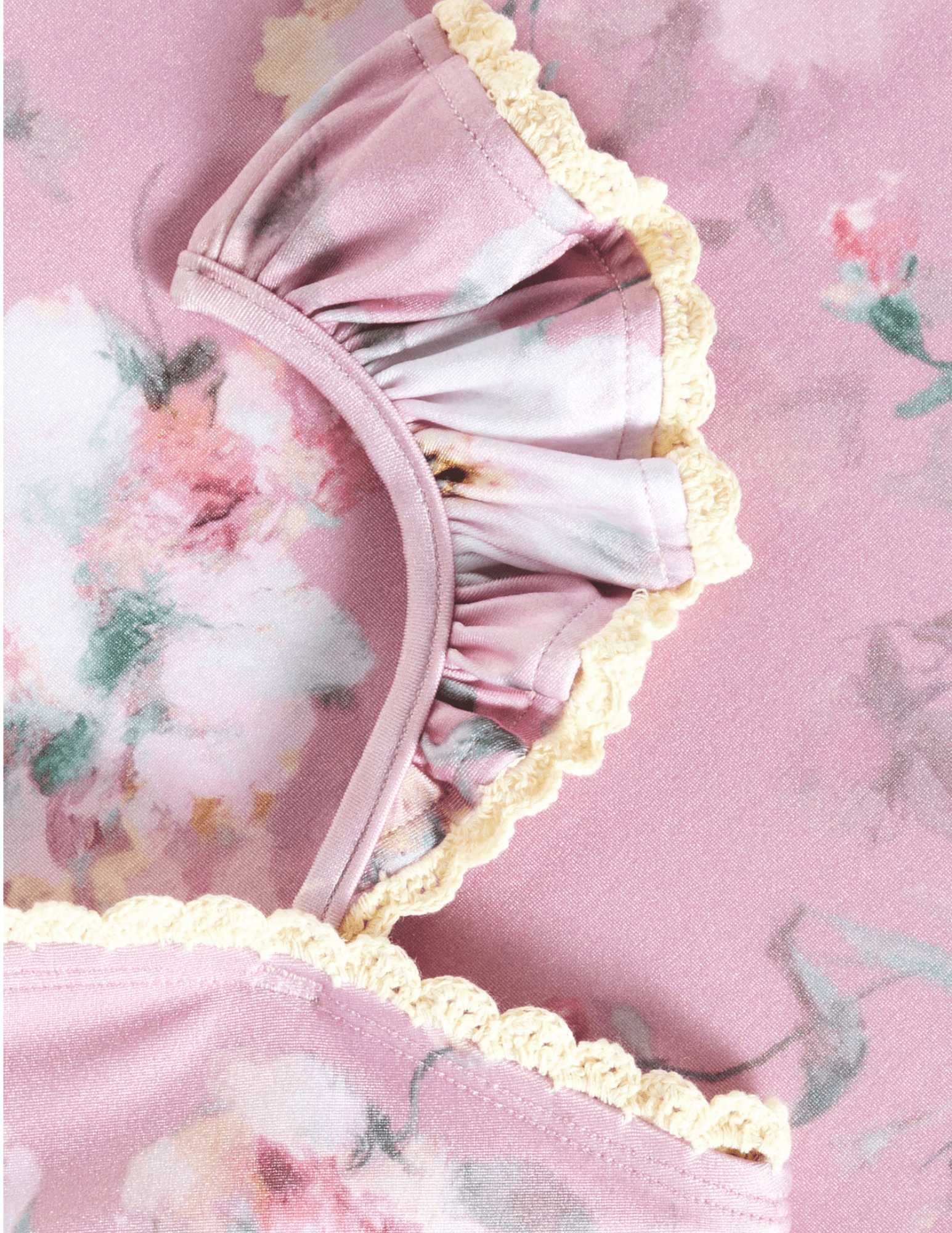 Close-up of Zimmermann Everley pink floral swimsuit with crochet trim and ruffle straps