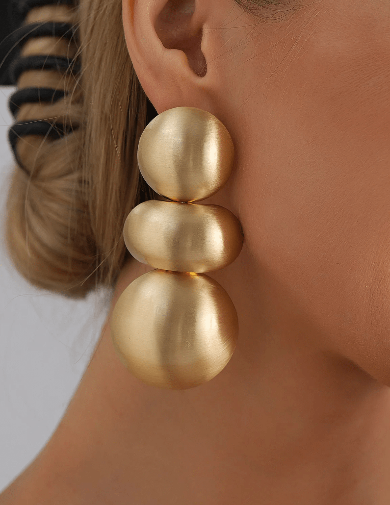 Austin Blaze Eliza statement earrings in brushed matte gold featuring a modern sculptural three-sphere drop design with standard post backing.