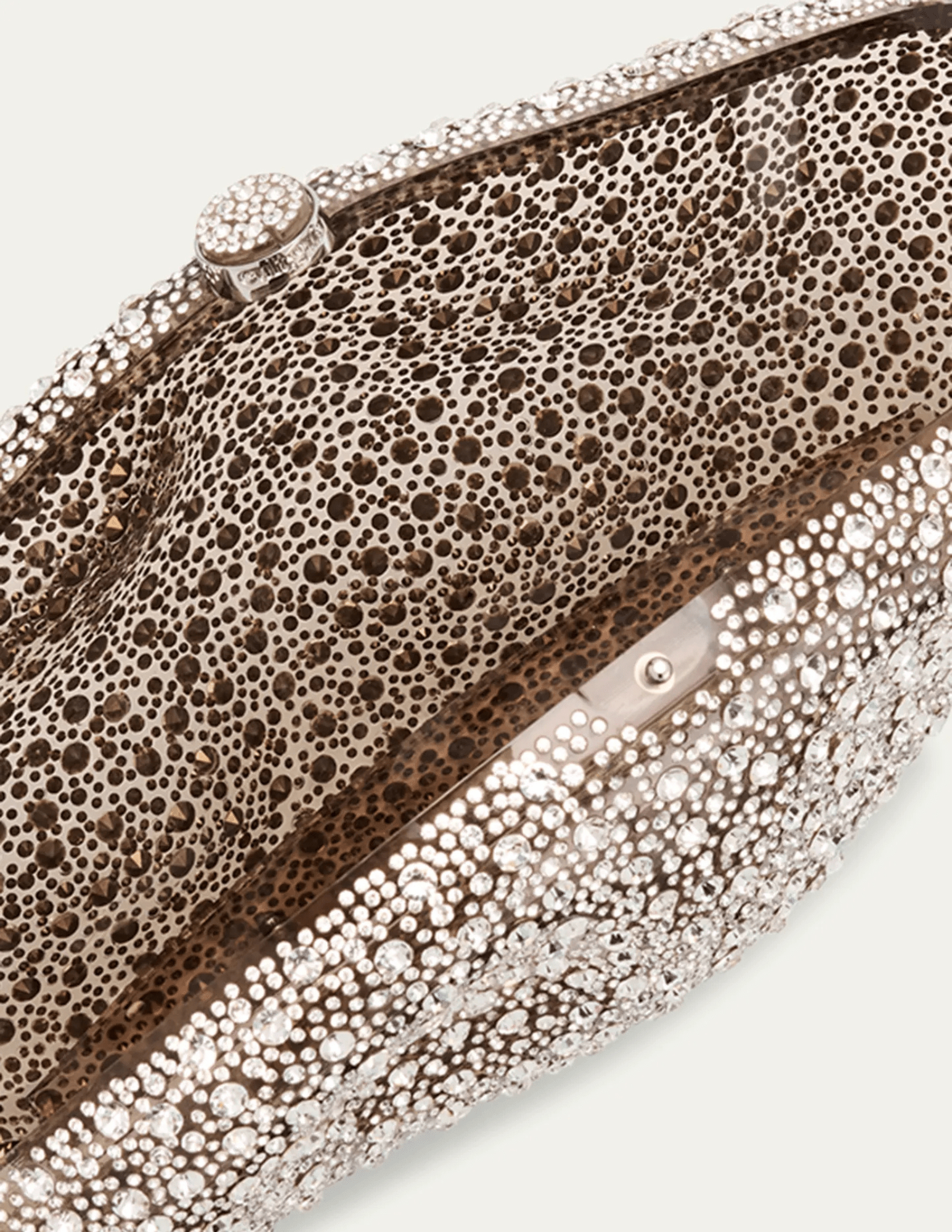 “Sculptural clear clutch with silver-tone clasp and textured glass detailing