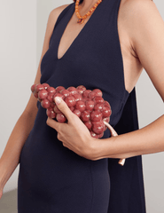 Model holding crimson Cult Gaia Grape Acrylic Clutch.