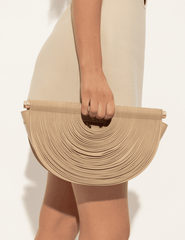 Model carrying Cult Gaia Lou Leather Top Handle Bag in sand woven leather