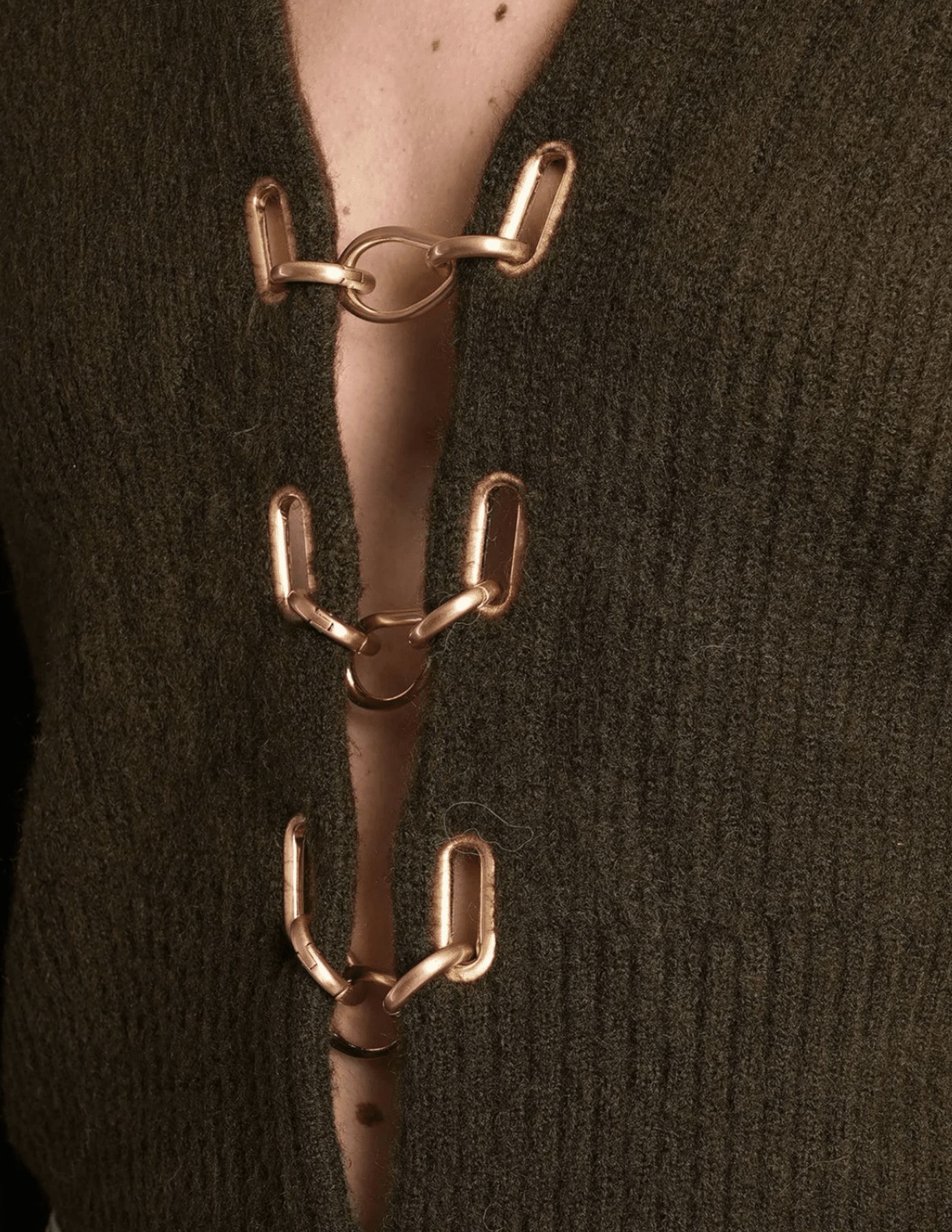 Close-up of gold chain clasp detail on Cult Gaia Mayalu Sweater