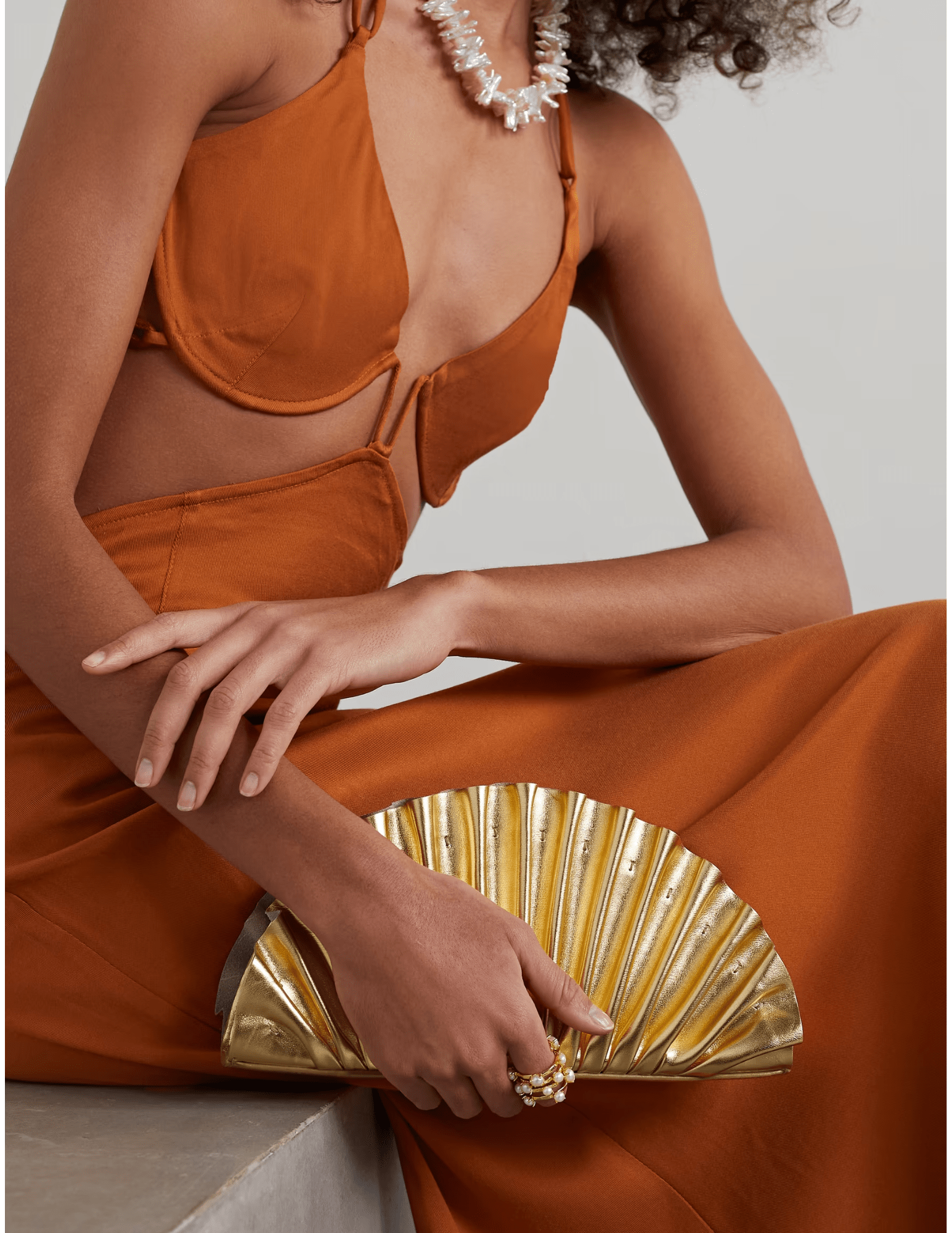 Model holding Cult Gaia Nala Mini Clutch in gold