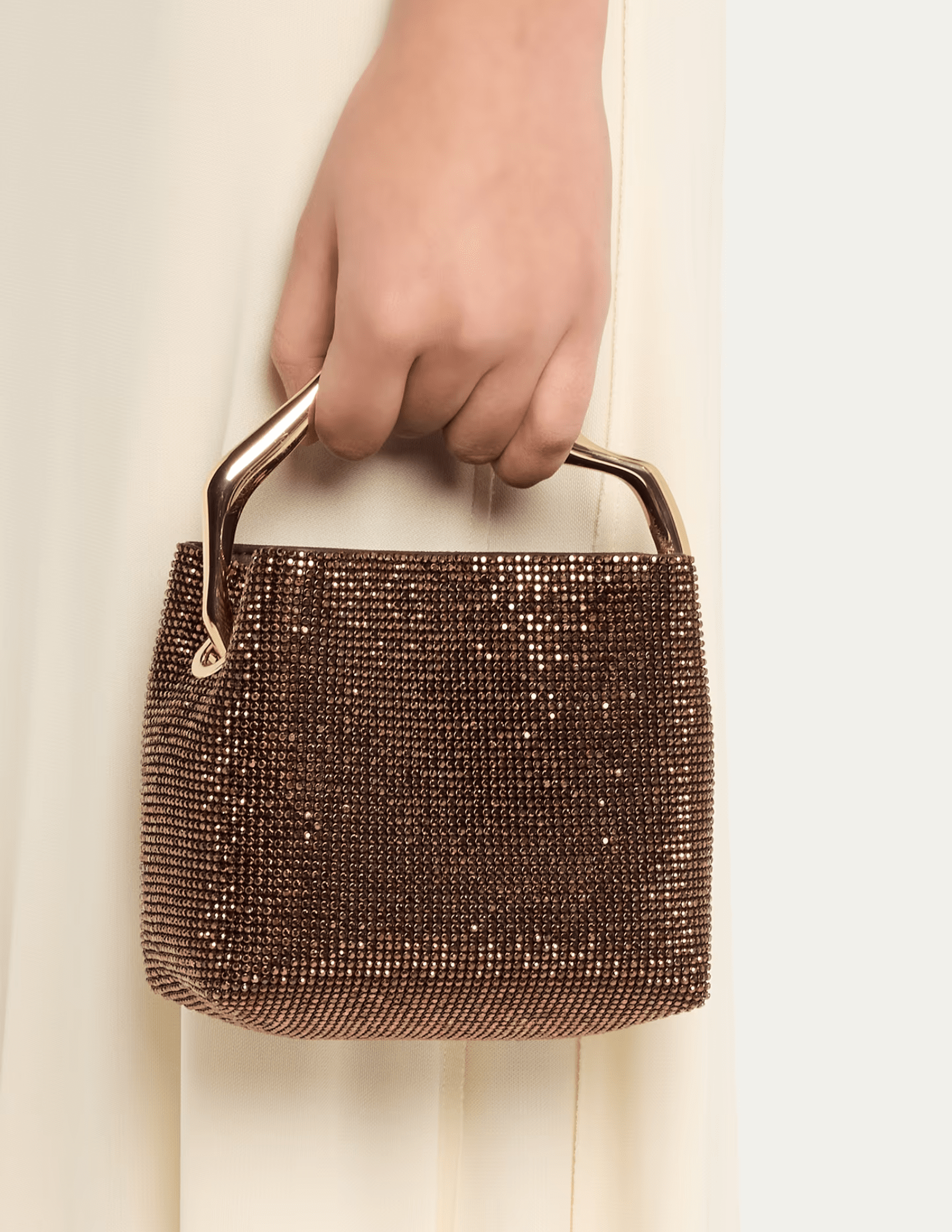 Cult Gaia Solene Mini Rhinestone Bag in Java carried by its sculptural gold-tone top handle.