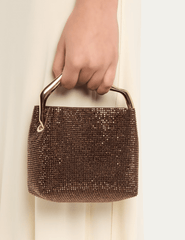 Cult Gaia Solene Mini Rhinestone Bag in Java carried by its sculptural gold-tone top handle.