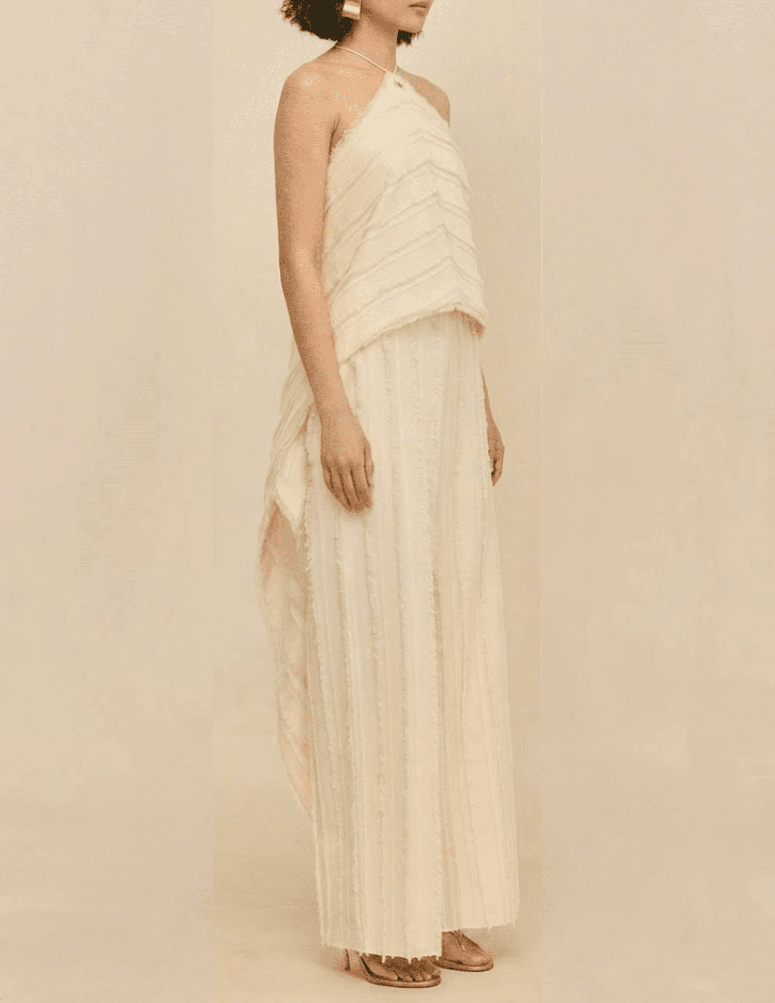 Side view of the Cult Gaia Venezia Halter Cascade Top in Off White highlighting the flowing silhouette