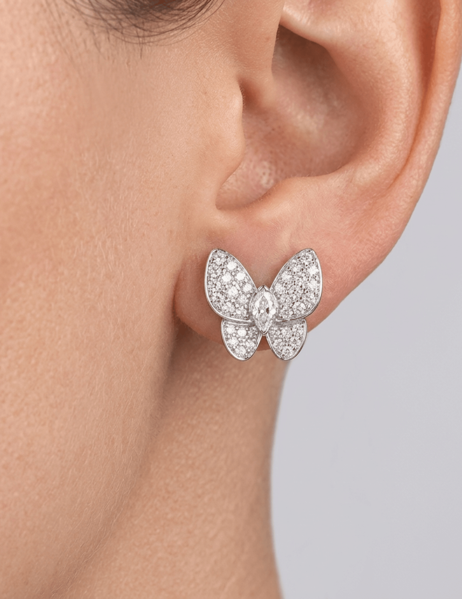 Close-up of silver pavé crystal stud earrings worn on ear