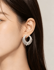 Model wearing Fleur de Camélia Parker CZ Silver Earrings showcasing the sparkling open-circle silhouette and statement design.
