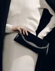 Model holding Hunting Season Opera black suede Western trim clutch with elegant neutral outfit