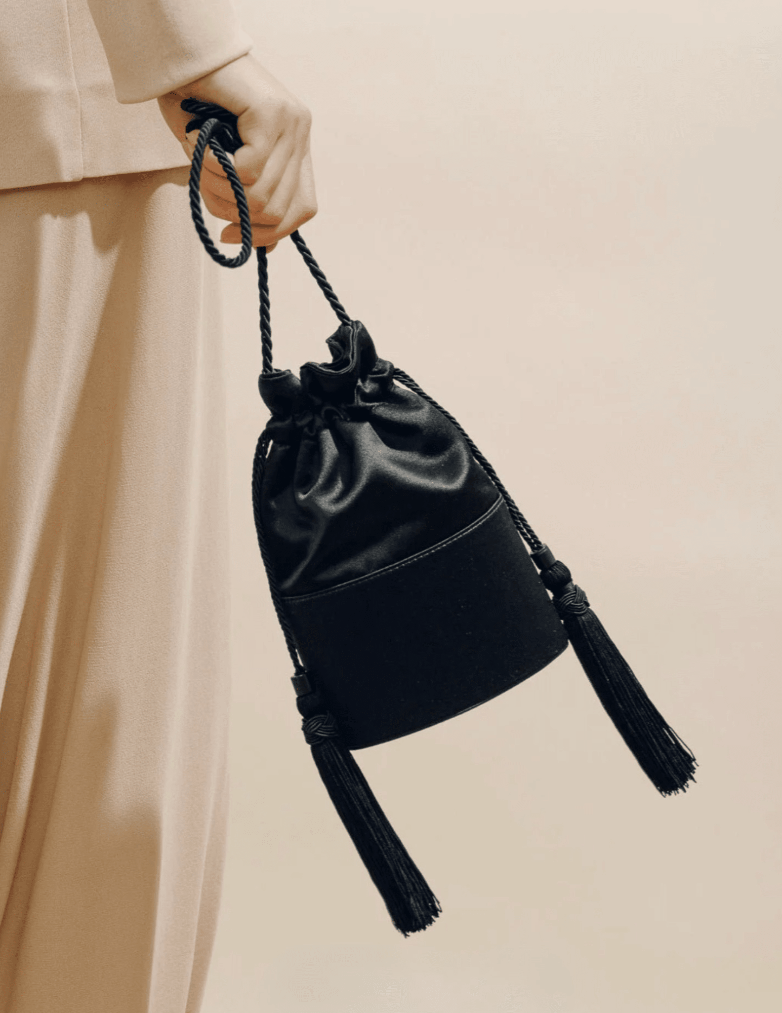 Close-up of Hunting Season Lola black satin handbag with tassel detailing