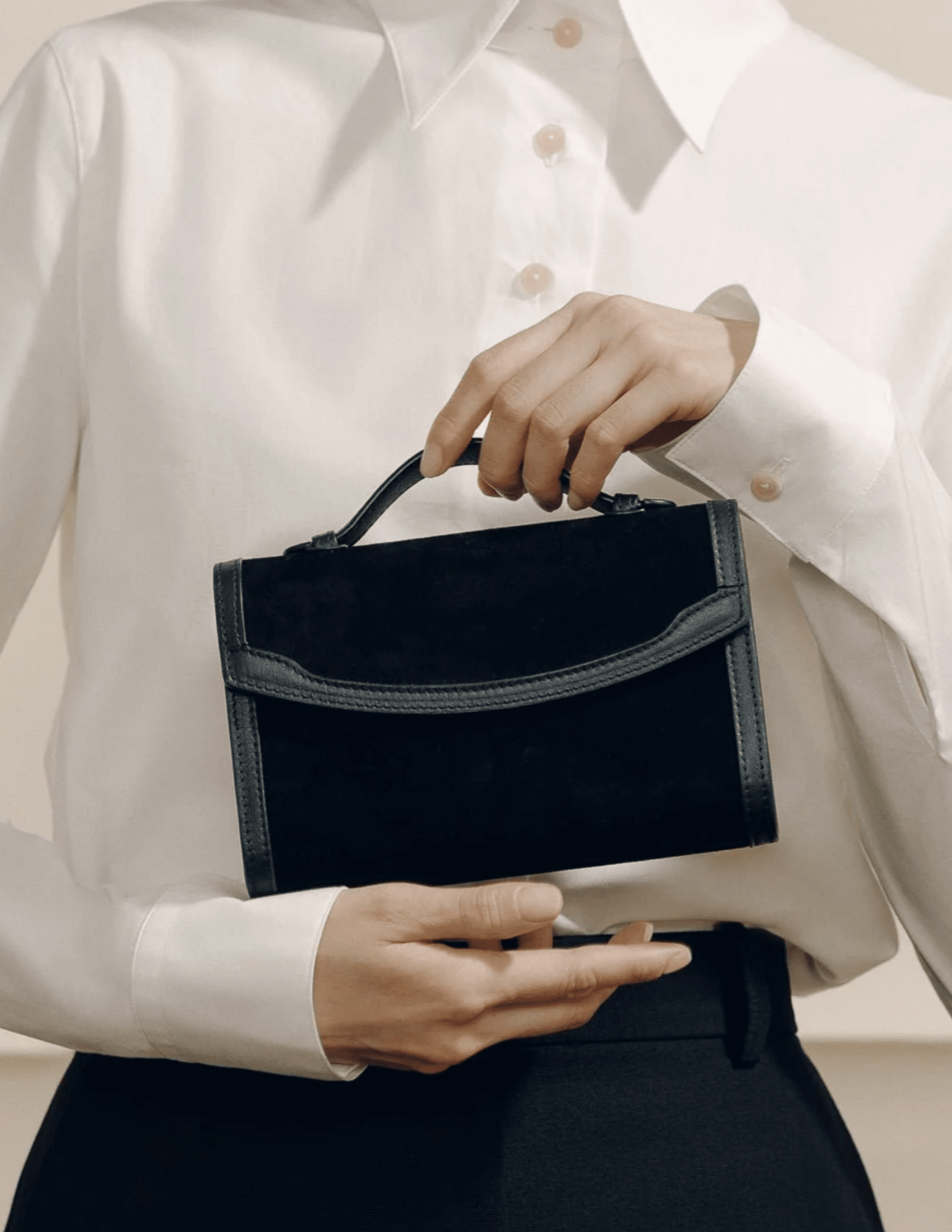 Model holding Hunting Season black suede Western trim clutch with white blouse