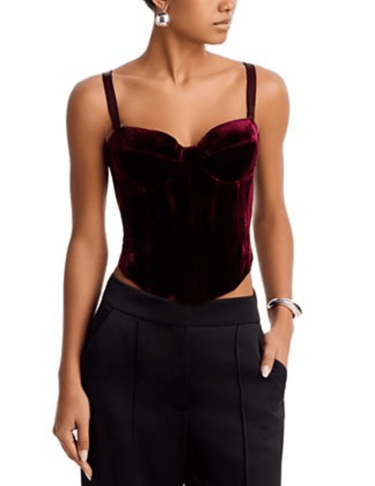 Model wearing L'AGENCE Ariana Deep Port Velvet Corset with black tailored trousers.