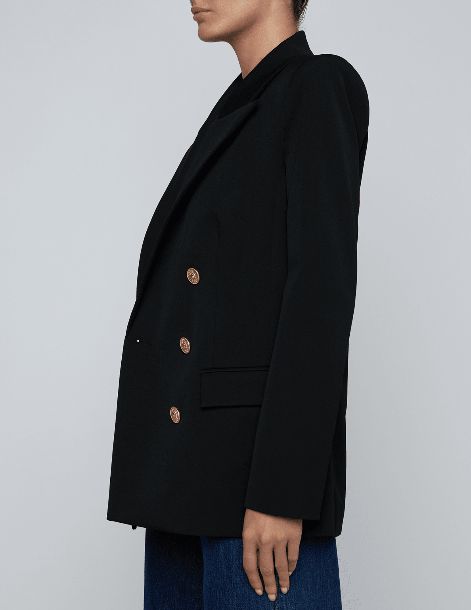 Side profile of oversized blazer with gold-tone lion buttons.