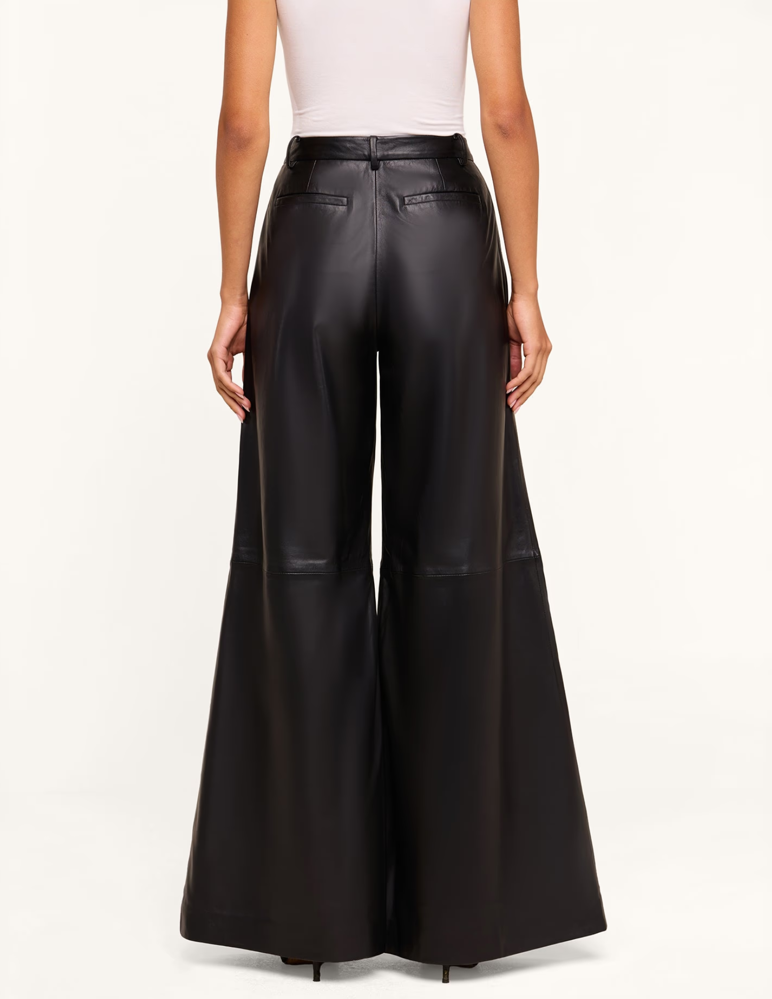 Back view of L'AGENCE Chelsy Black Leather Wide Leg Pants featuring a flowing wide-leg fit.