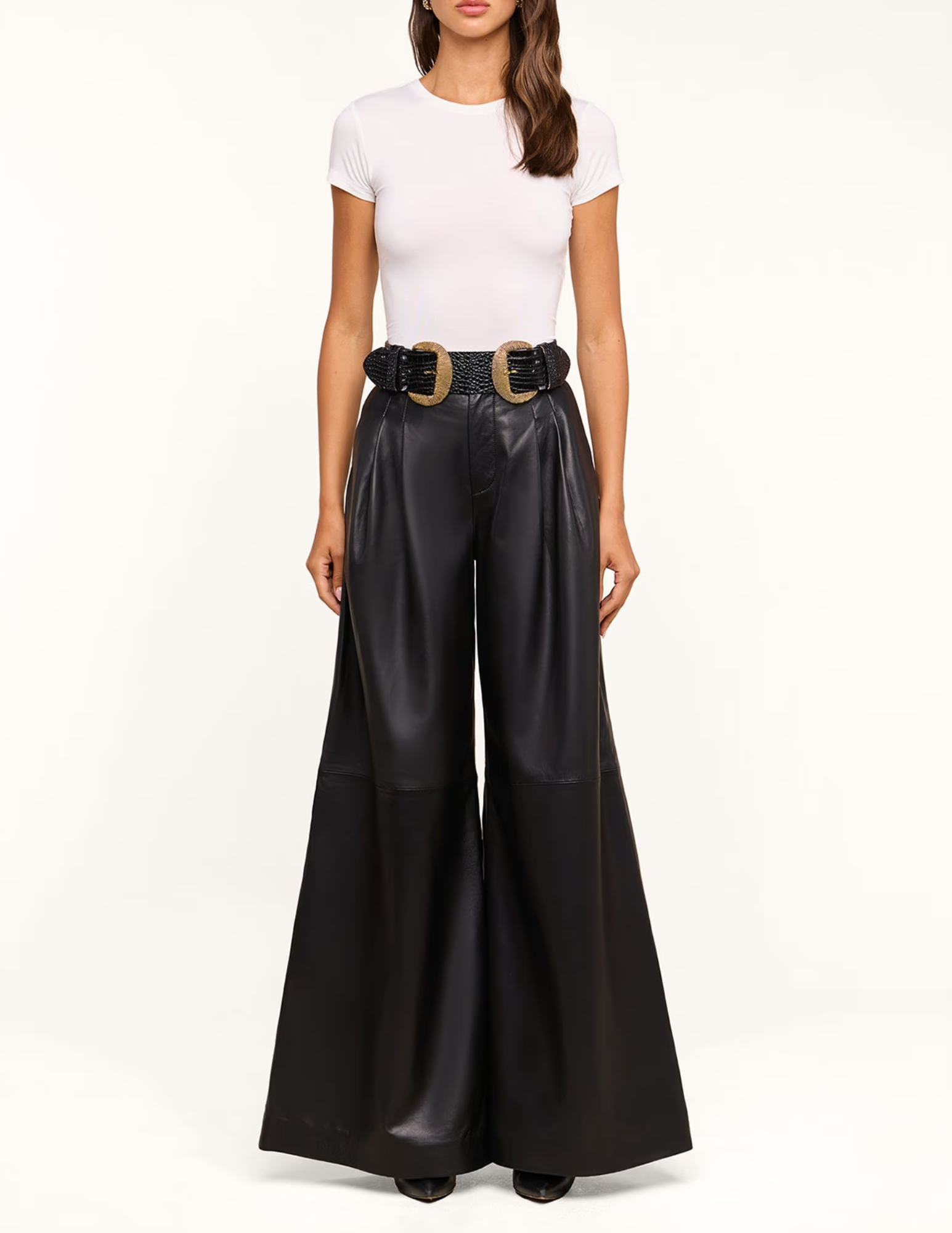 Model styling L'AGENCE Chelsy Leather Wide Leg Pants in Black with a white fitted top and statement belt.