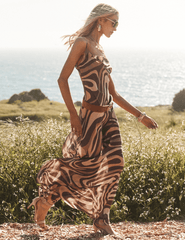 Model wearing L'AGENCE Christine abstract swirl silk maxi dress outdoors