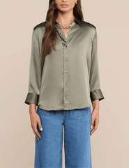 Model wearing L'AGENCE Dani silk blouse in Smokey Olive with wide-leg jeans