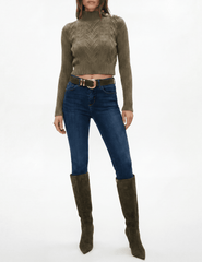 Model wearing L'AGENCE Kamdyn Grape Leaf Gold mock neck sweater with jeans and tall boots.