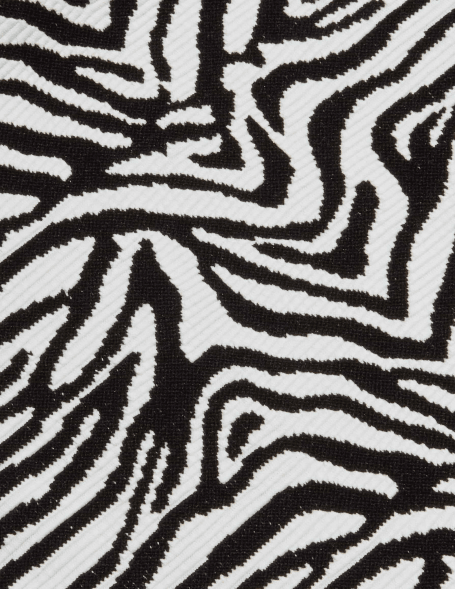 Close-up of textured black and white zebra print fabric on L'AGENCE Karmin swimsuit.