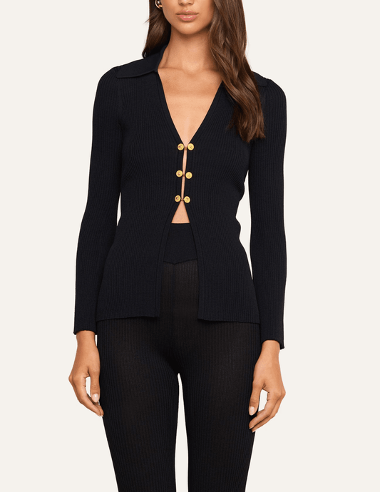Model wearing L'AGENCE Kaye Black Gold Cardigan Top with tailored black trousers.