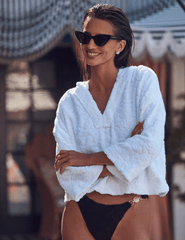 Model wearing L’AGENCE Lee Terry Cropped Hooded Poncho styled as a swim cover-up