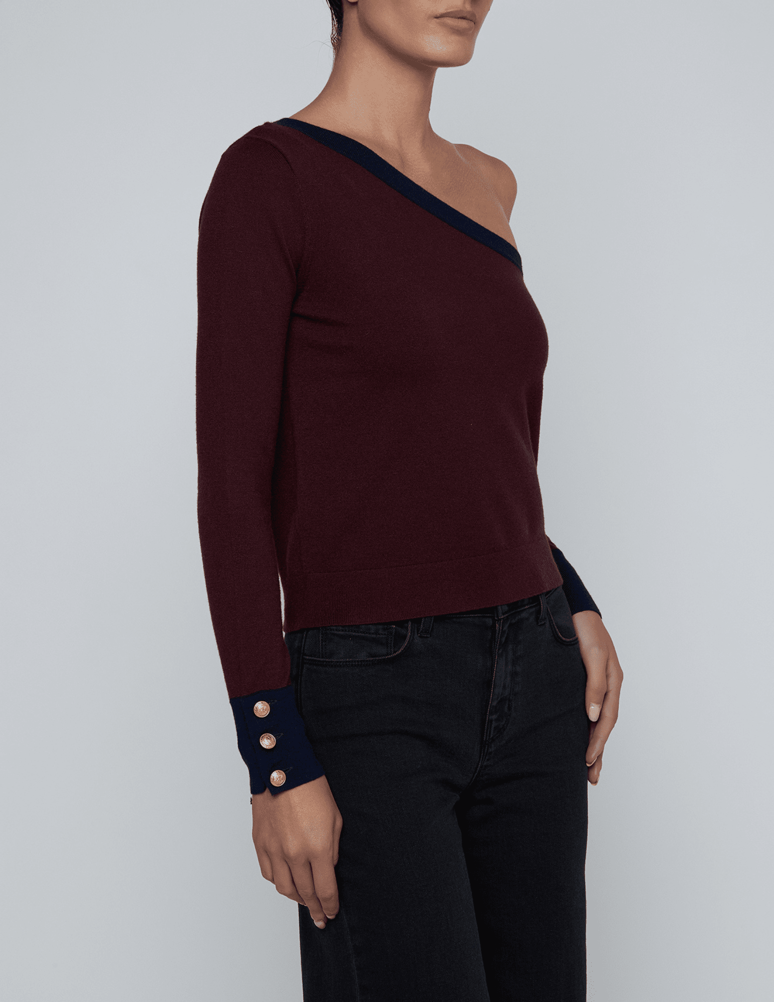 Side angle of Maeva One Shoulder Sweater showing slim fit and button cuff detail.
