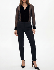 Model wearing L’AGENCE Marisol Velvet Sheer Bodysuit in black with tailored pants.