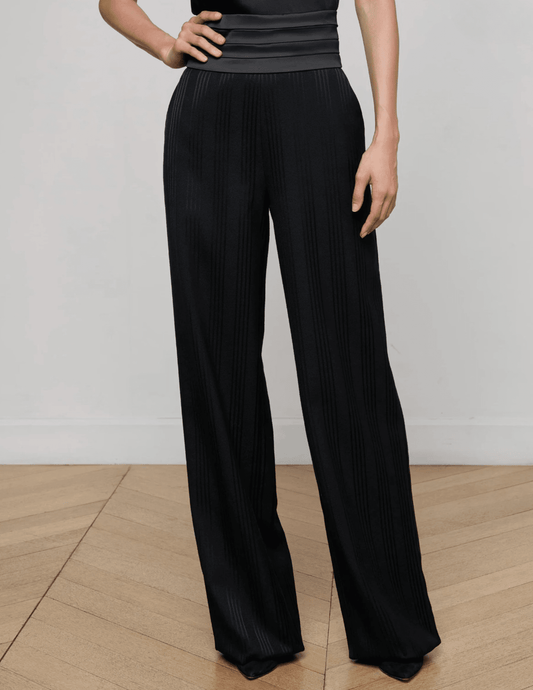 Model wearing L’AGENCE black shadow-striped wide-leg trousers with cummerbund waist