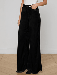 Model wearing L’AGENCE Quincy Wide Leg Corduroy Jeans in Black with high-rise waist.