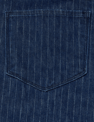 Close-up detail of the metallic pinstripe texture on denim