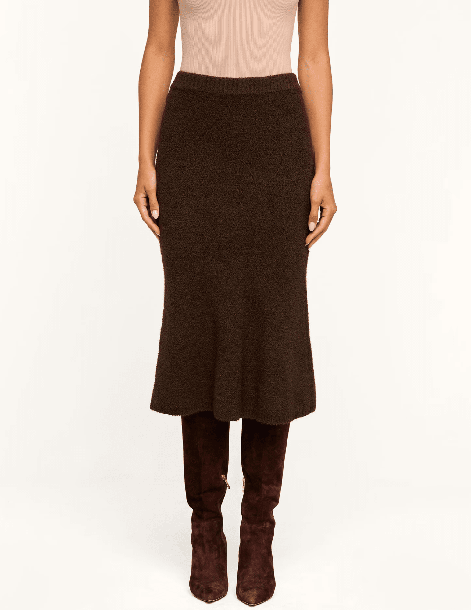Model wearing L'AGENCE Salem Dark Brown Knit Midi Skirt with a fitted silhouette and flared hem.