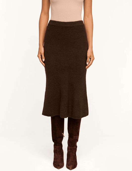 Model wearing L'AGENCE Salem Dark Brown Knit Midi Skirt with a fitted silhouette and flared hem.