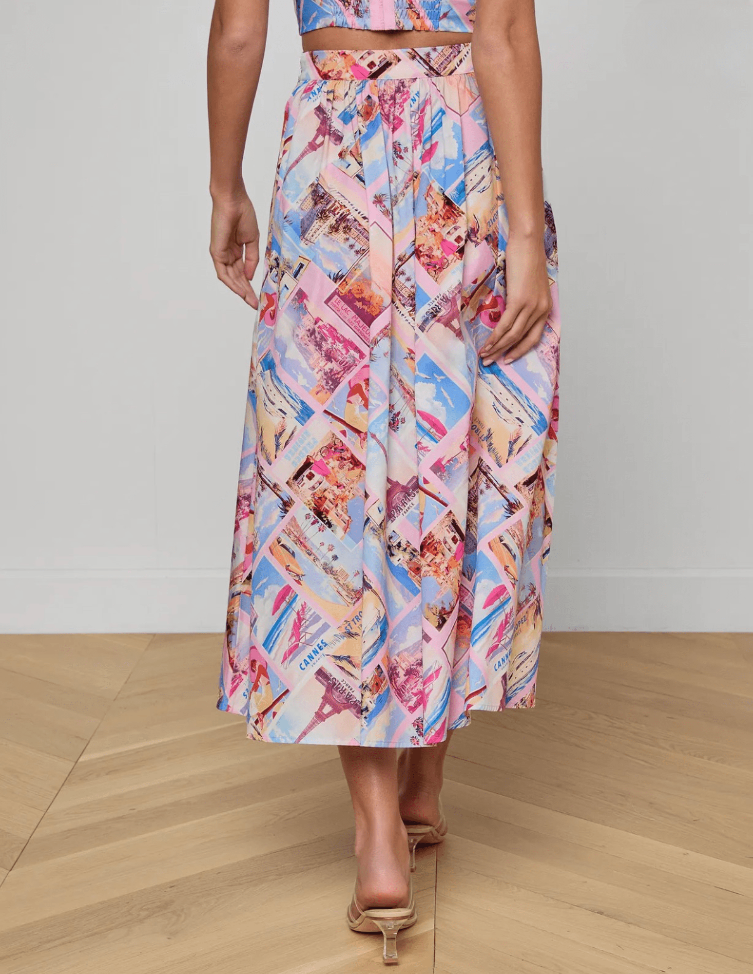 Back view of L'Agence Seina midi skirt in pink postcard print