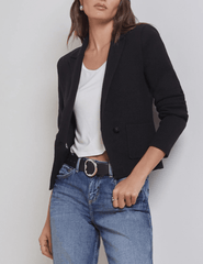 Model wearing L’AGENCE Sofia Knit Blazer in black, styled with white top and blue jeans.
