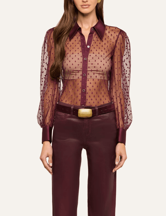 Model wearing L'AGENCE Sophie Swiss Dot Blouse in Deep Port styled with burgundy leather trousers.