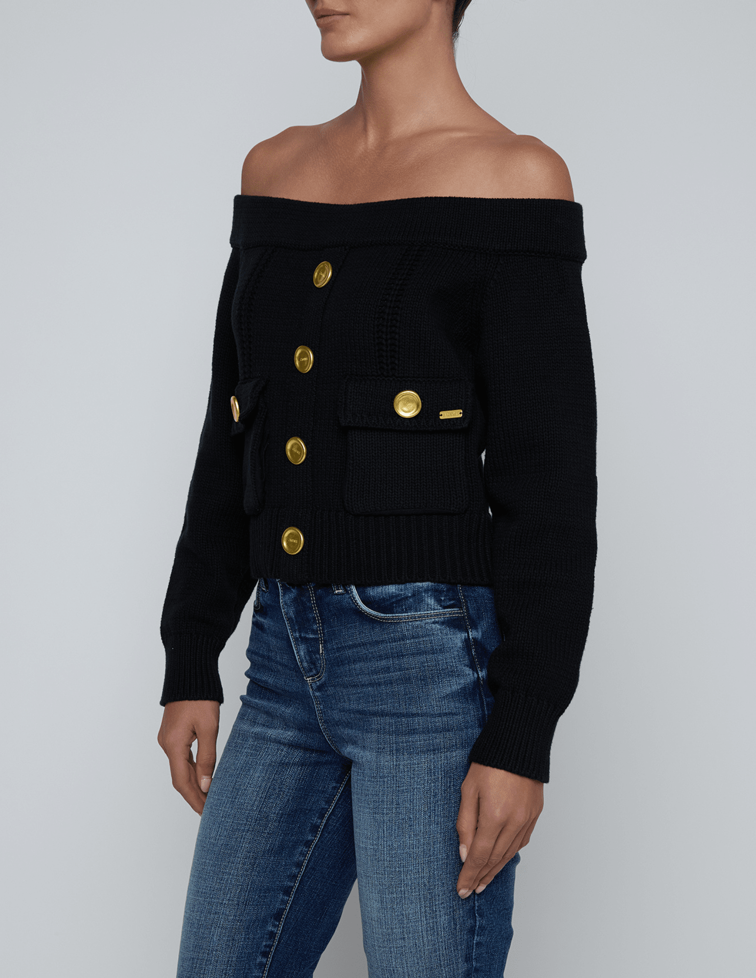 Side view of L’AGENCE Teri Off-Shoulder Cargo Sweater in black knit with cargo details.