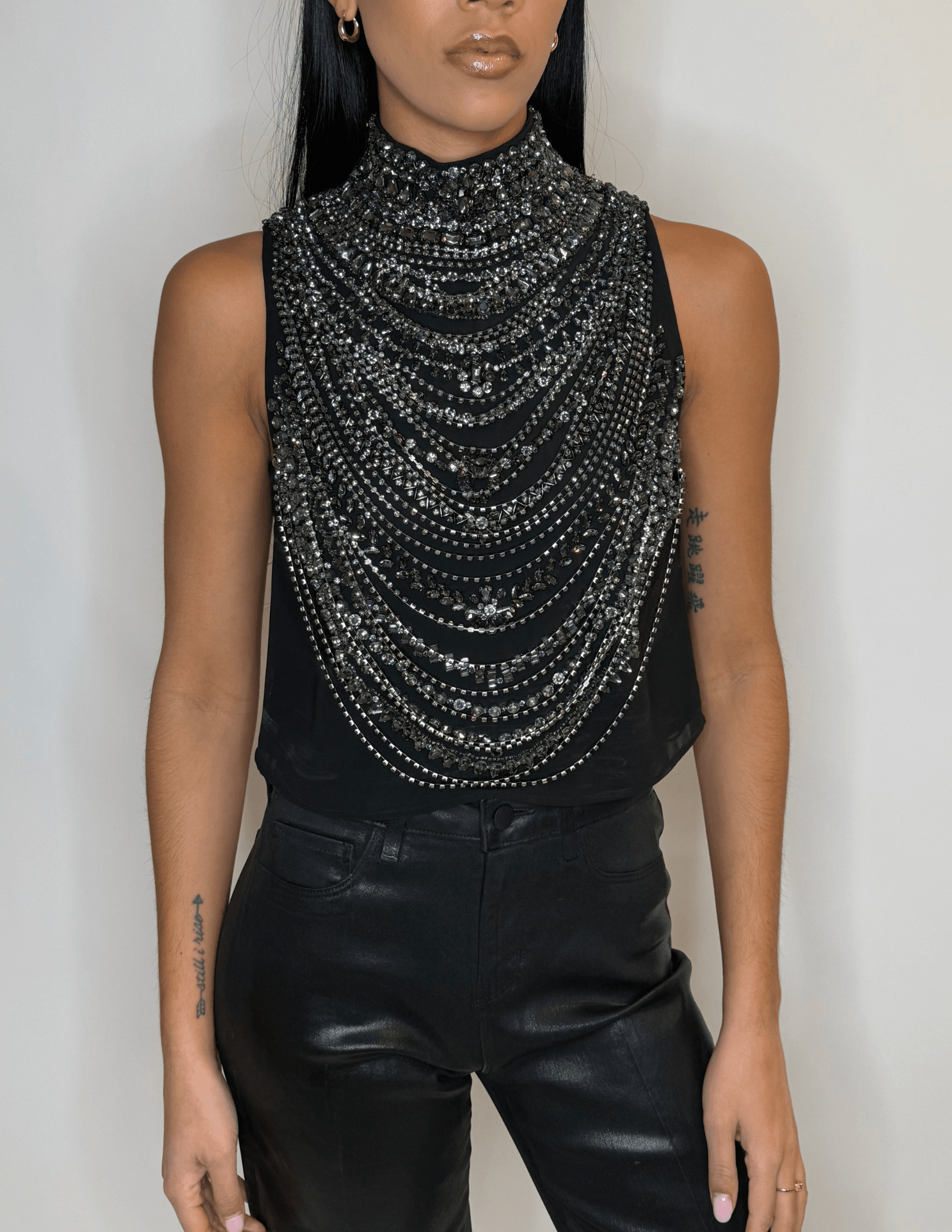 Front view of L'AGENCE Yun black tank with cascading smokey grey crystals.