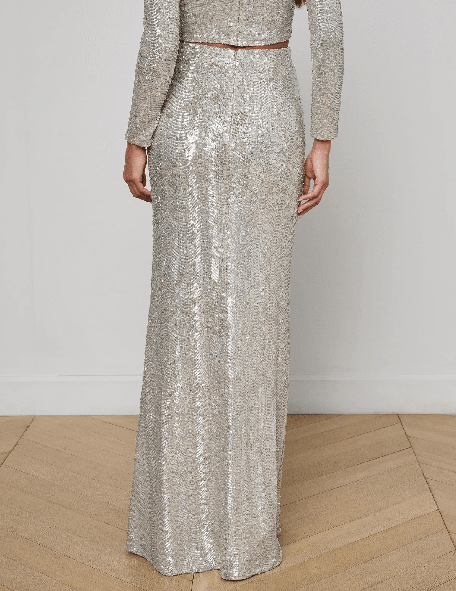 “Back view of L’AGENCE Zeta Sequin Maxi Skirt in shimmering silver swirl sequins.”