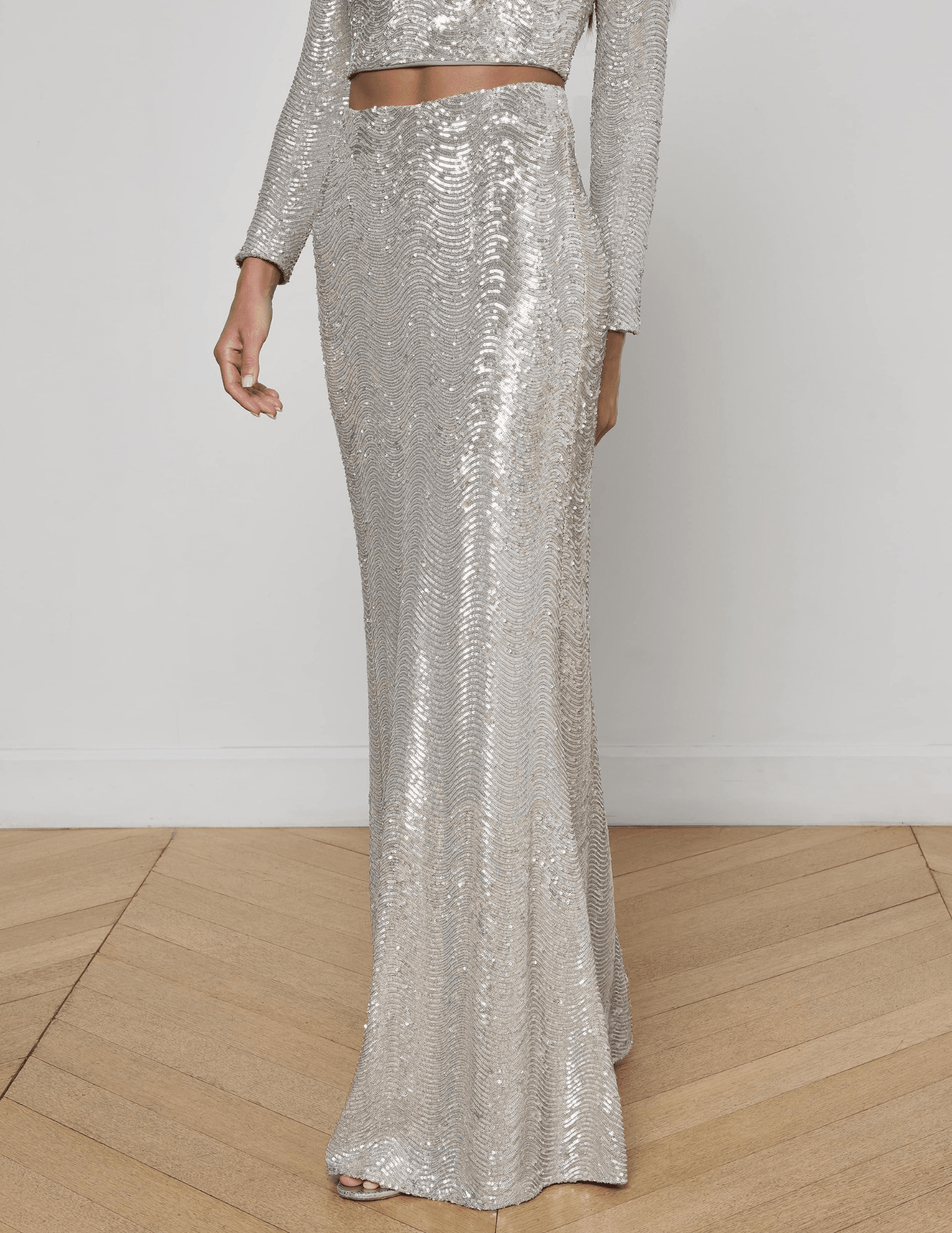 “Side view of L’AGENCE Zeta Sequin Maxi Skirt in shimmering silver swirl sequins.”