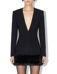 Model wearing Ronny Kobo Aivy black tailored mini dress with deep V-neckline and faux fur hem
