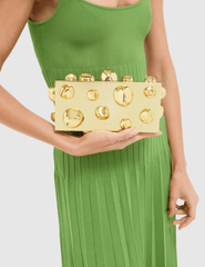 Model styling Cult Gaia Orbs Clutch in shiny gold with cocktail outfit