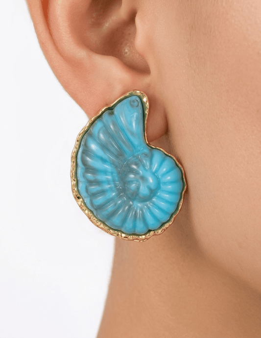 Model wearing blue enamel seashell earrings with gold trim