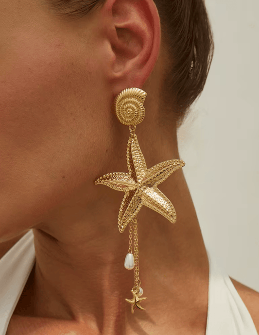 Model wearing St Barths gold starfish statement earrings